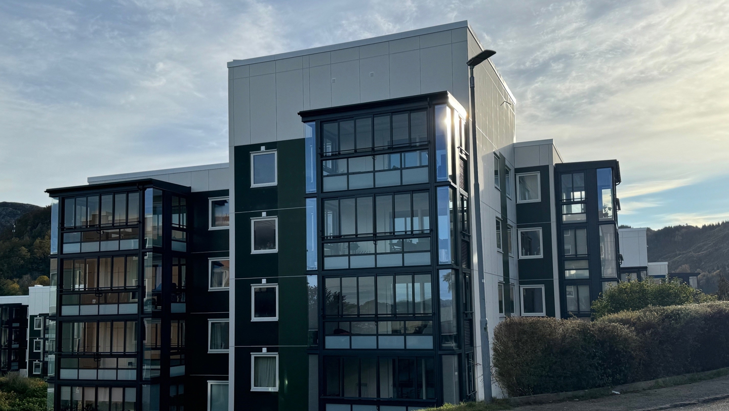 En gammel boligblokk har fått en ny fasade med innglassede balkonger.