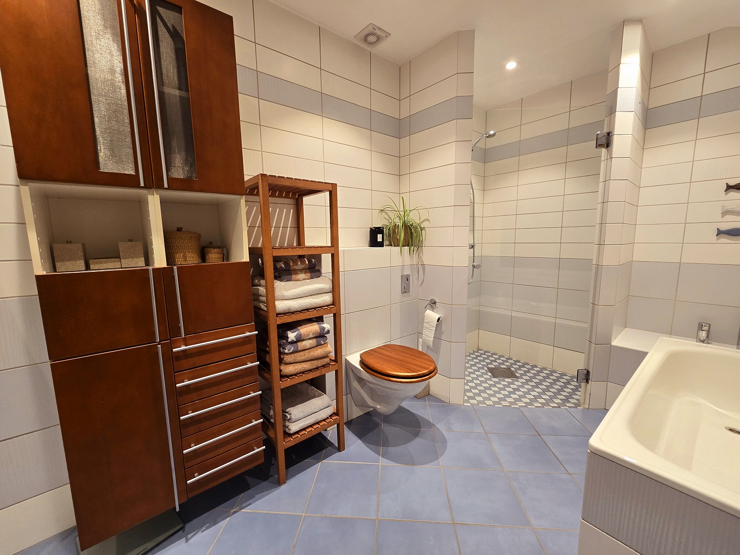 Et eldre, litt utdatert bad med fliser i forskjellige farger.