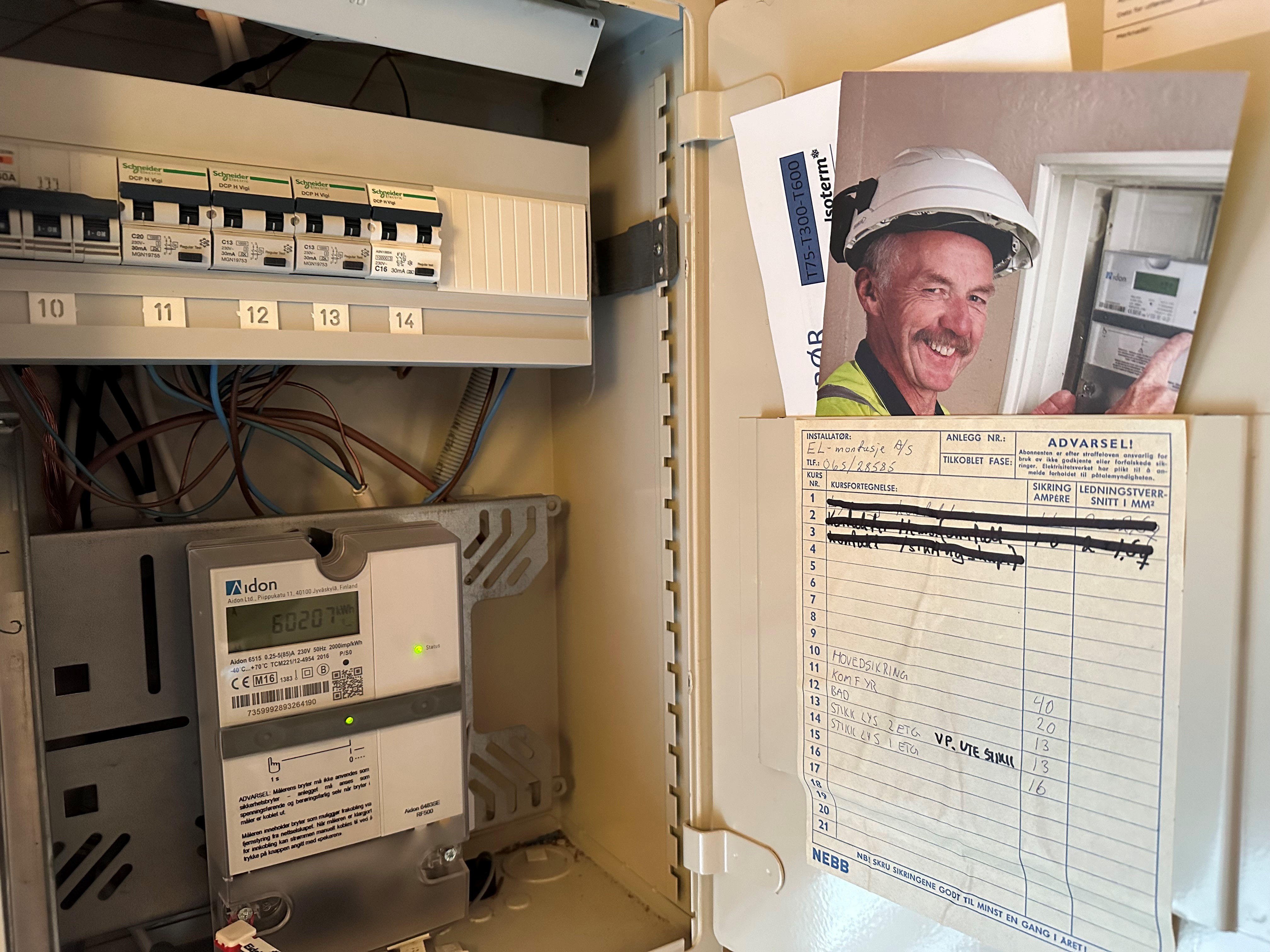 Bilde av et åpent sikringsskap med oversikt over sikringer og strømkurser.